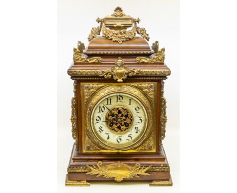 A large late 19th century bracket clock with stylised brass supports and decoration, handle decoration to top and stylised Ar