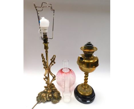 A 19th century brass oil lamp with twisted column and accompanying engraved glass shade and funnel, with spare funnel, along 