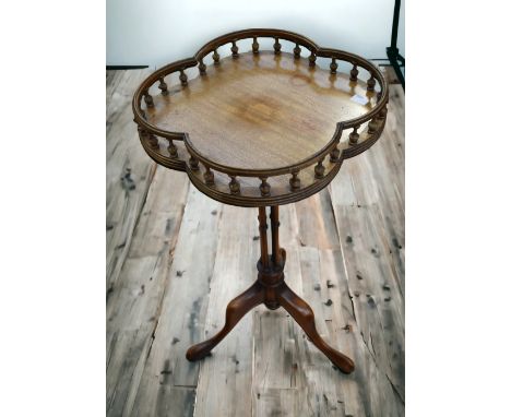 A reproduction mahogany gallery tripod wine table along with a brass and cast umbrella/stick stand.