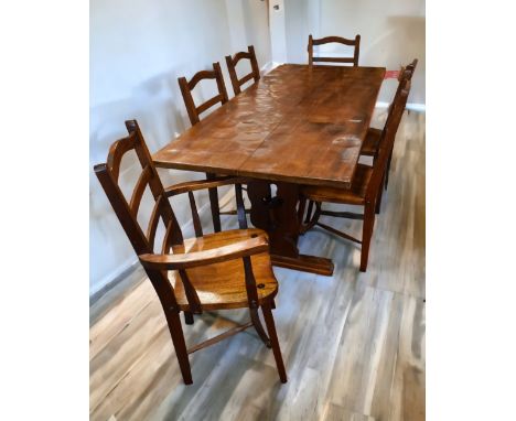A 20th Century English provincial carved oak dining table with six ladder back dining chairs (4 + 2 armchairs), length of tab