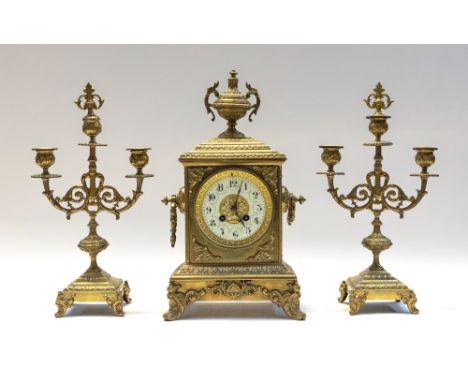 A late 19th century clock garniture, brass cased bracket clock with stylised Nouveau designed dial and urn shaped finial to t
