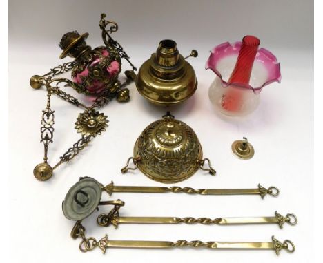 A late 19th century ruby glass hanging oil lamp, with elaborate brass casing and detail, in the Neo-Classical style and with 