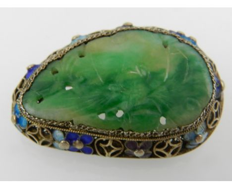 A silver, jade, and enamel brooch, the pierced green jade plaque set in an openwork mount decorated with cloisonne enamelled 