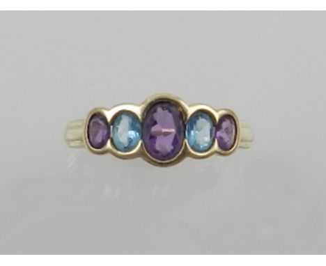 A 9 carat yellow gold, amethyst, and aquamarine ring, set five graduating stones, bears hallmarks to shank. 