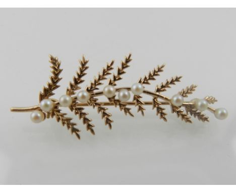 A 9 carat yellow gold and pearl set brooch in the form of a fern leaf, hallmarked to verso. 