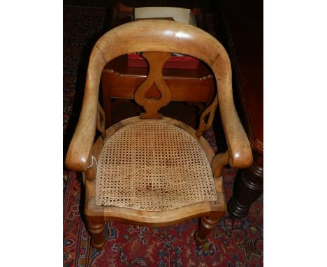 A Victorian stained beechwood smokers bow elbow chair, with caned seat on turned legs. 