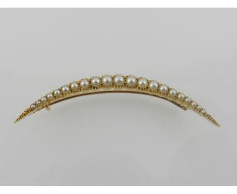 A yellow metal and pearl mounted crescent brooch. 