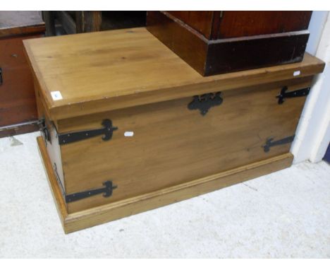 A pine trunk, the plain top above wrought iron bound sides and twin handles to plinth base