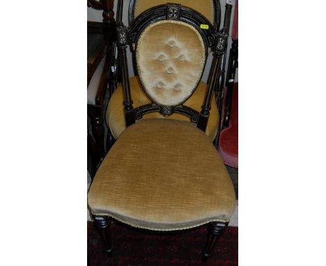 A Victorian ebonised and gilt decorated salon chair with spoon back and button seat and mustard coloured upholstery together 