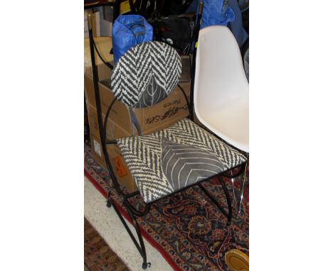 An early 20th Century wrought iron and brass framed hall chair in the Theban taste with upholstered back panel and seat on an