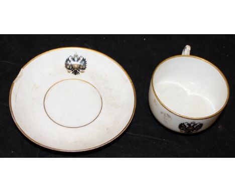 A Kuznetsov porcelain cup and saucer bearing the Arms of Tsar Nicholas II, being a twin headed spread eagle with armorials an