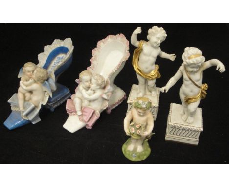 A Dresden cherub and shoe posy vase, a similar blue ground vase, porcelain putti with flowers figure, a pair of Capodimonte p