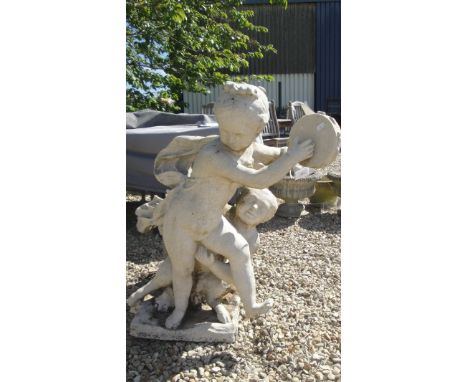 A composite stone statue group of putti playing tambourine and cloven hoofed satyr