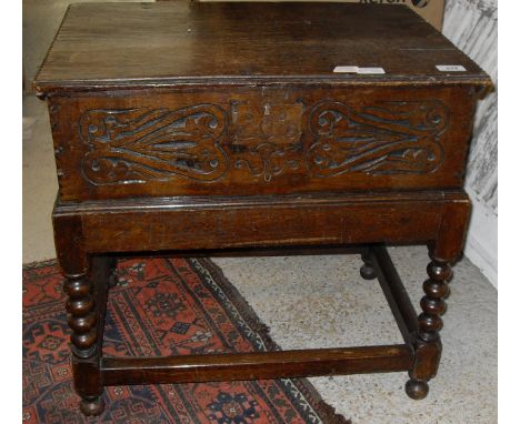 An 18th Century oak Bible box, the single piece top with moulded and notch carved decoration above a carved panel front, rais