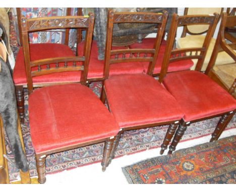 A set of six Edwardian walnut framed dining chairs with carved top rail above red upholstered seats to turned front legs toge