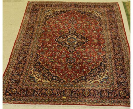 A Persian style carpet, the central panel set with floral decorated medallion on a red ground within a stepped blue, purple a