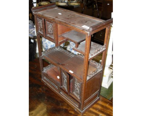 A Chinese cherry wood table top display cabinet with various shelving and two pairs of carved cupboard doors over two drawers