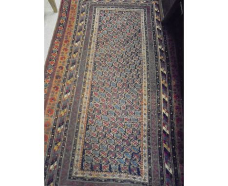 A Persian style carpet, the central panel set with repeating stylised floral motifs on a dark blue ground within a stepped bl