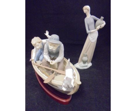 A Lladro figure of a Fisherman with boy and dog in a rowing boat "Paloma" impressed "5215" to the base, the whole on a hardwo