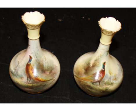 A pair of Edwardian Royal Worcester porcelain vases of hand painted decoration of cock pheasants in a woodland landscape sign