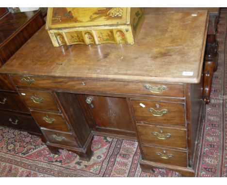 A George III mahogany knee hole desk, the single piece top with moulded edge above a single frieze drawer and recessed cupboa