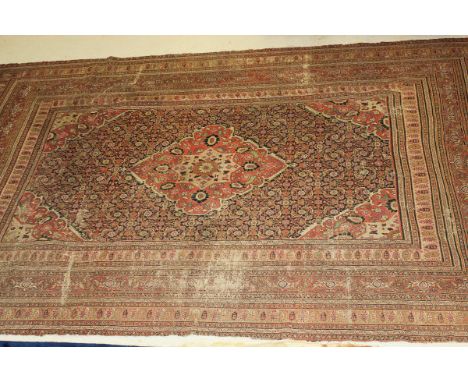 A Persian carpet, the central panel set with a medallion with stylised bird and floral decoration on a black and red similarl