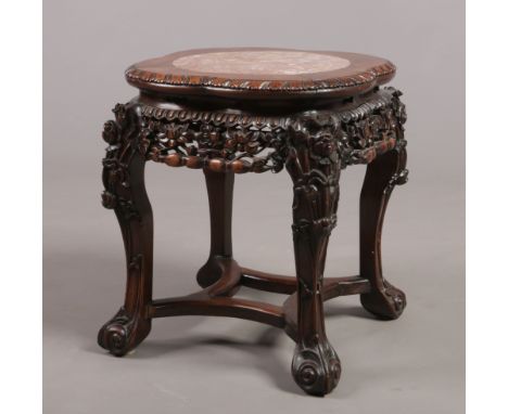 A 19th century Chinese hardwood and pink marble vase stand. With gadrooned quatrefoil top, foliate pierced frieze and raised 