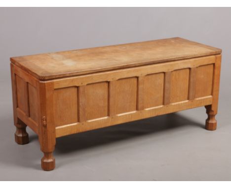 A Robert Thompson Mouseman Yorkshire oak coffer. With pegged two-plank top having adzed finish, panelled sides and raised on 