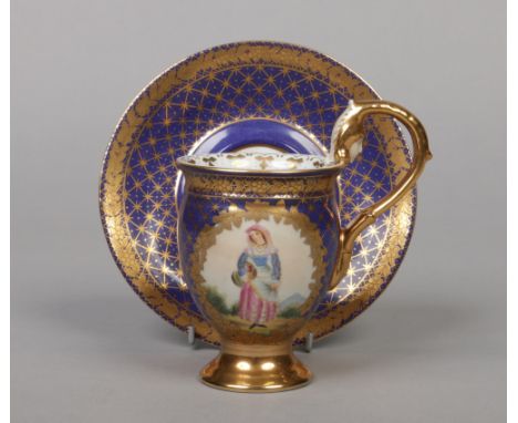 A 19th century Berlin cabinet cup and saucer with scrolling handle having unglazed mask and acanthus terminal. Ground in coba