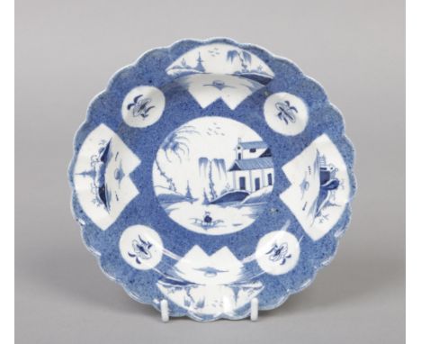 An uncommon early Caughley scalloped plate. Powder blue ground, with fan and round reserves painted with Chinese landscapes. 