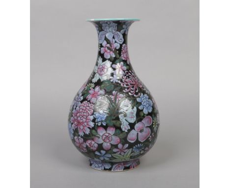 A Chinese famille noir pear shaped vase. Decorated in coloured enamels with mixed flowers and with turquoise glazed interior.