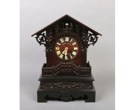 A 19th century Black Forest cuckoo mantel clock. With triangular pediment, acanthus scrolling corbels and an open fret balust