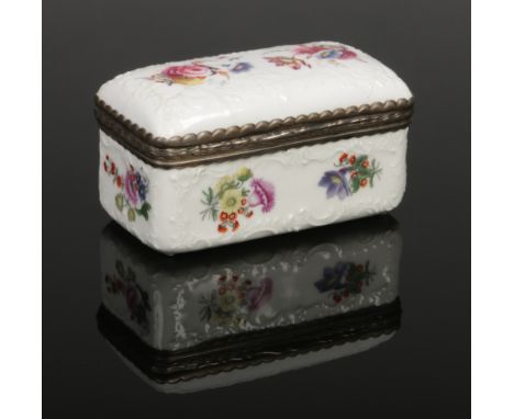 An early 19th century Coalport snuff box with hinged cover and metal mount. With scroll moulding and painted with flowers. Pu