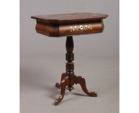 A Victorian centre pedestal rosewood work table. With canted rectangular top ornamented with mother of pearl inlay and with f