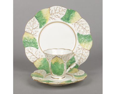 A Rockingham primrose leaf moulded coffee cup with crossed-twig handle, a saucer and a side plate. The leaves having alternat