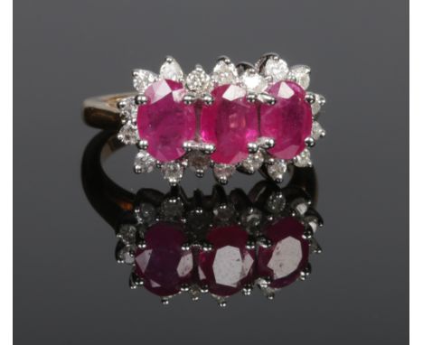 A 9ct gold ruby and diamond triple cluster ring set with three ovoid rubies and eighteen brilliant cut diamonds, total diamon