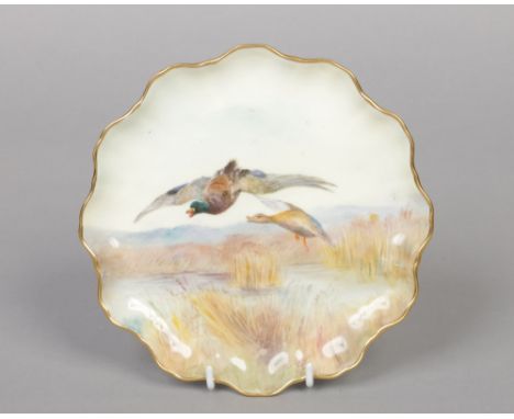 A Royal Doulton scalloped cabinet plate painted by C. Hare. Decorated with a pair of mallards in flight. Signed, printed mark