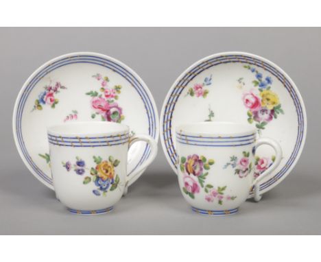 A pair of 18th century Sevres coffee cups and saucers painted with flowers under blue line and gilt borders, painted L marks.