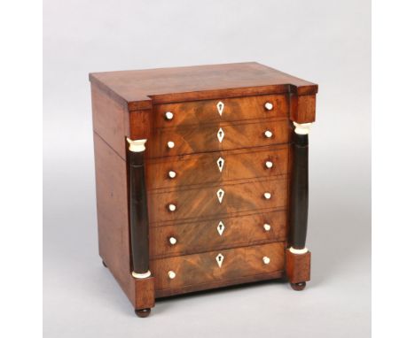 A fine Regency mahogany six bottle tantalus formed as a chest of drawers. With turned supports and having ivory handles and e