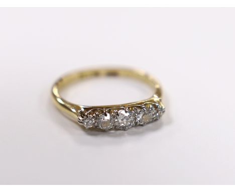 A 1920's 18ct, plat and graduated five stone diamond set half hoop ring, size K/L, gross weight 2.6 grams.