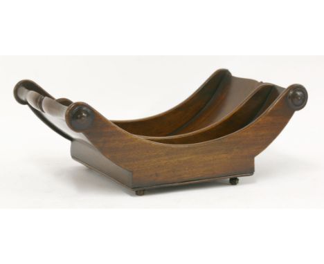 A George III mahogany cheese coaster,with a central division, on roller castors,43cm long