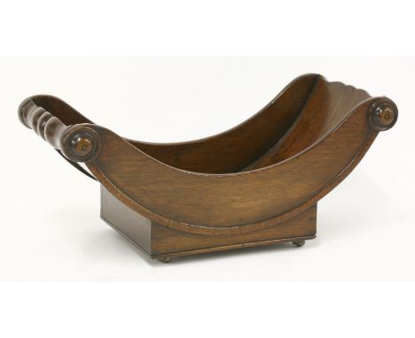 A George III mahogany cheese coaster,with turned ends and wooden roller castors,43.5cm long19cm high