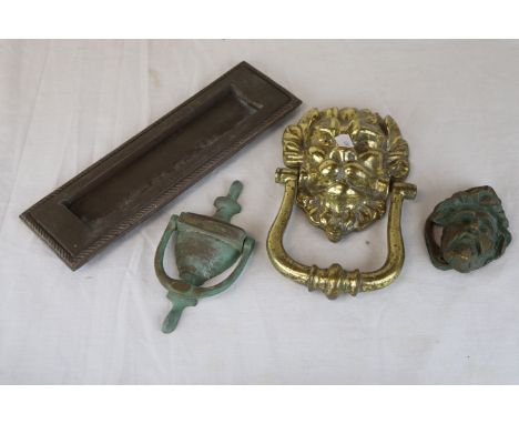 Brass lion mask door knocker, a face door knocker, an urn door knocker and a letter box 