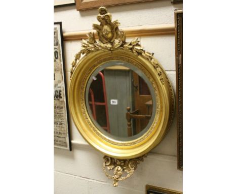 19th century Carved Giltwood Circular Bevelled Edge Mirror surmounted by scrolling leaves, total height 93cms