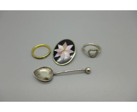 A silver ring, P, an eternity ring, R, a mother of pearl brooch/pendant and a silver salt spoon 