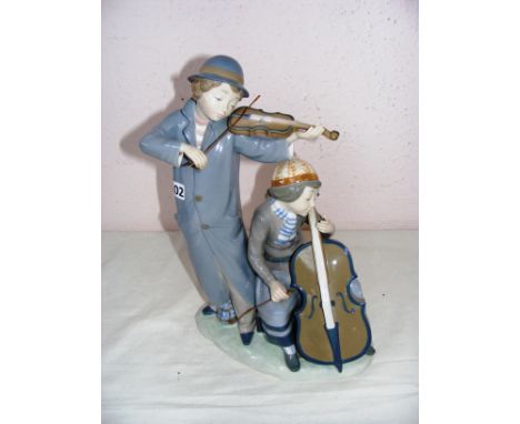 A Nao by LLadro large figurine of boy playing violin & girl base violin, it measures CONDITION REPORT: Has a firing crack sho