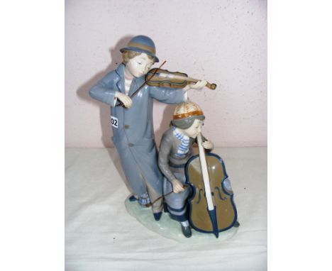 A Nao by LLadro large figurine of boy playing violin & girl base violin, it measures CONDITION REPORT: Has a firing crack sho