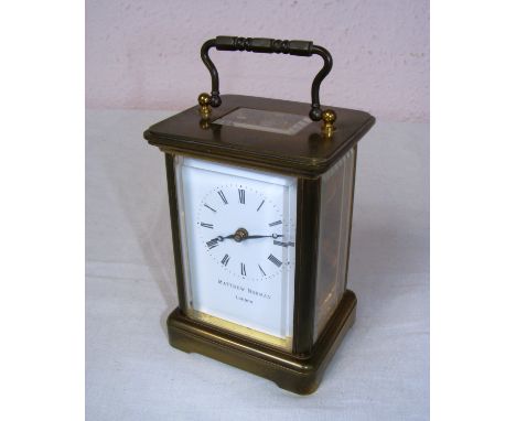 A Matthew Norman London brass carriage clock with bevelled glass panels and swing handle, the movement numbered '1754', in go