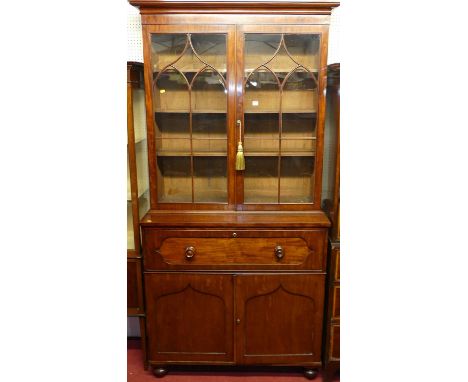 A mid-Victorian plum-pudding mahogany secretaire bookcase, having twin glazed upper doors enclosing adjustable shelves, over 