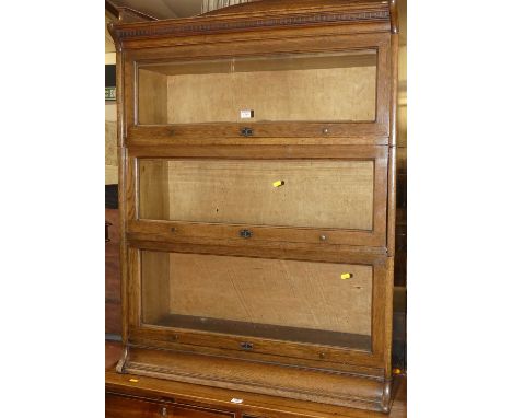 A 1930s oak three-tier stacking bookcase by the Lebus Bookcase Company, with raised ledgeback and typical hinged glazed doors